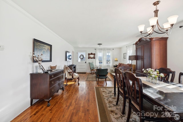 dining area featuring dark hardwood / wood-style flooring, an inviting chandelier, and ornamental molding