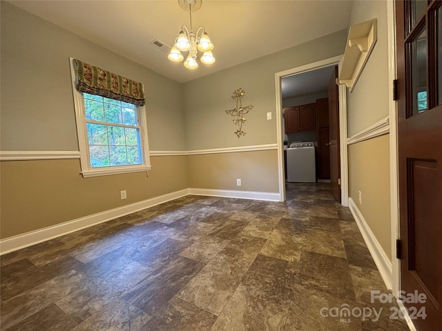 unfurnished dining area with a notable chandelier and washer / clothes dryer