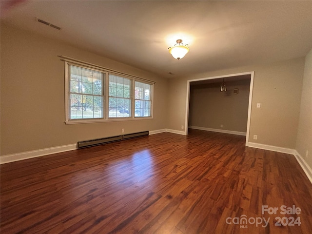 empty room featuring a baseboard radiator and dark hardwood / wood-style floors