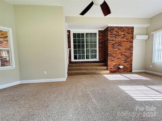 unfurnished living room with ceiling fan, brick wall, carpet flooring, and a wall mounted air conditioner