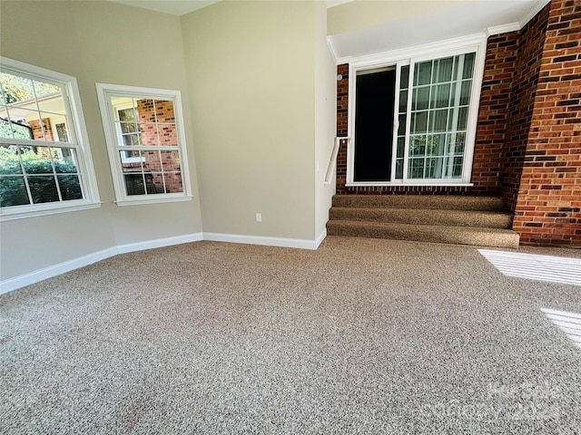 spare room with brick wall, ornamental molding, and carpet floors