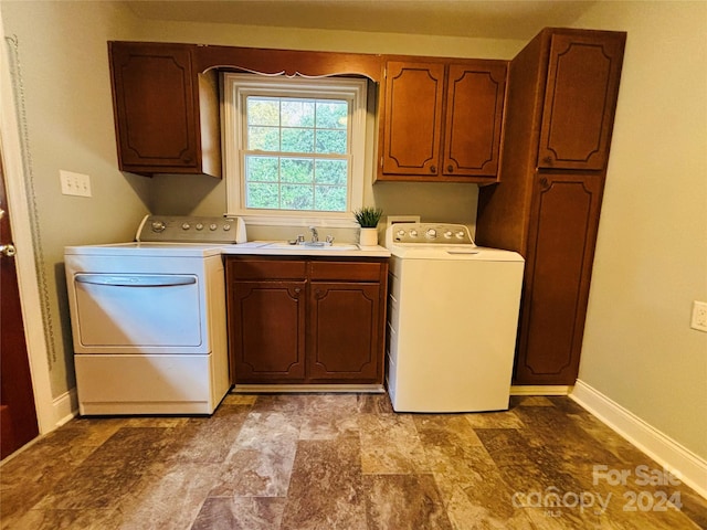 laundry area with sink, washing machine and dryer, and cabinets