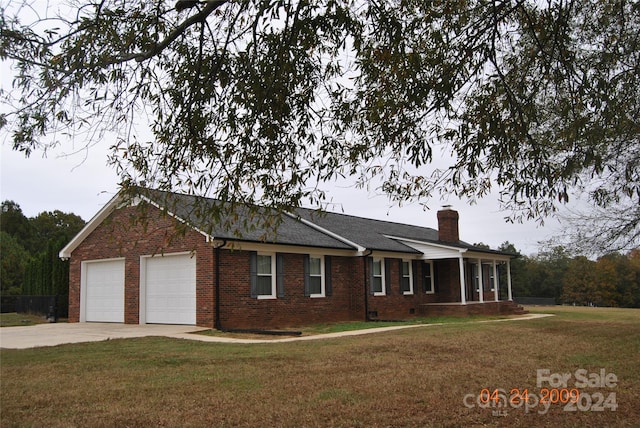 ranch-style home with a garage and a front lawn