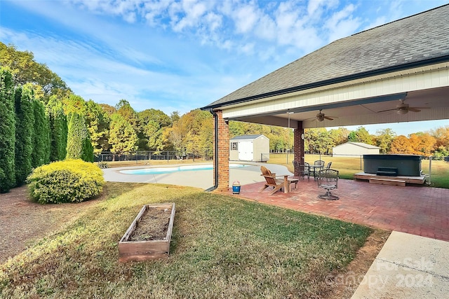 view of yard with a shed, ceiling fan, a fenced in pool, and a patio