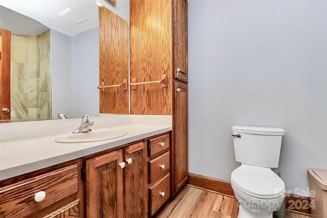 bathroom with walk in shower, wood-type flooring, vanity, and toilet