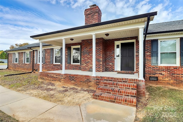 view of exterior entry with a porch