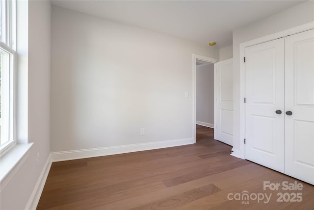 unfurnished bedroom featuring hardwood / wood-style floors and a closet