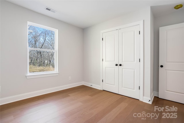 unfurnished bedroom with hardwood / wood-style flooring and a closet