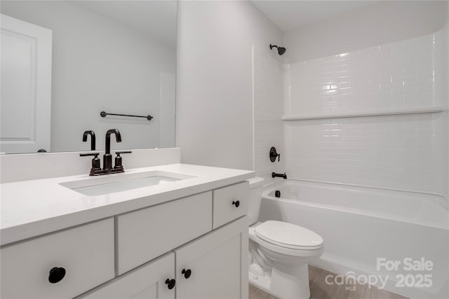 full bathroom with vanity, tiled shower / bath, and toilet