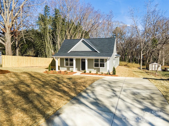 view of front facade with a front yard, covered porch, and a storage unit