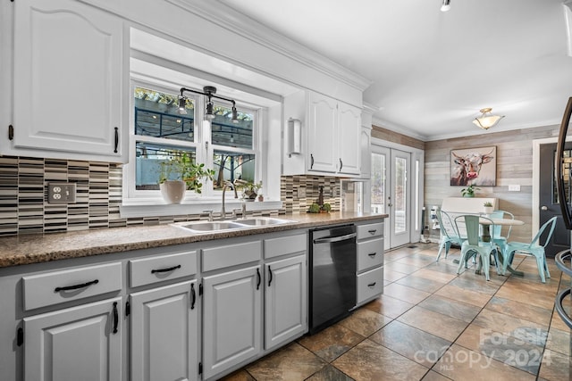 kitchen featuring a wealth of natural light, stainless steel dishwasher, sink, and white cabinets