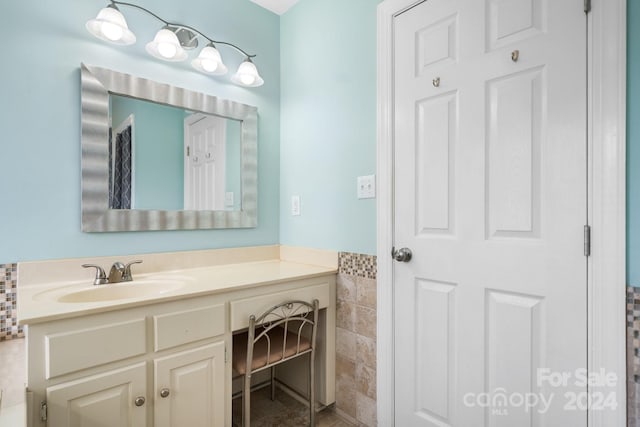 bathroom featuring vanity and tile walls