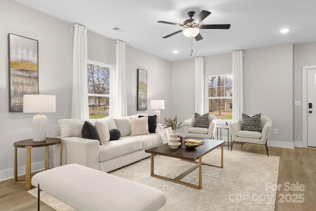 living room with ceiling fan and light wood-type flooring