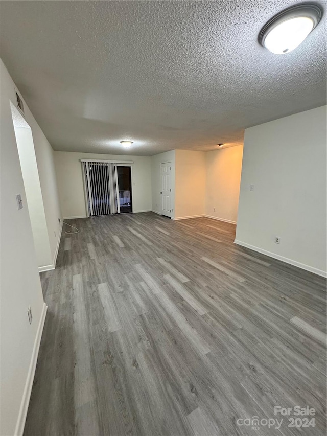 spare room with a textured ceiling and wood-type flooring