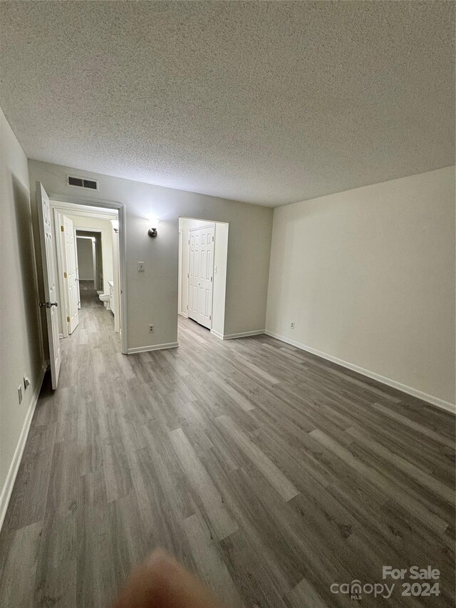 2123 Carriage Woods Ln, Kannapolis, NC 28081 - unfurnished room with dark wood-type flooring, baseboards, and a textured ceiling