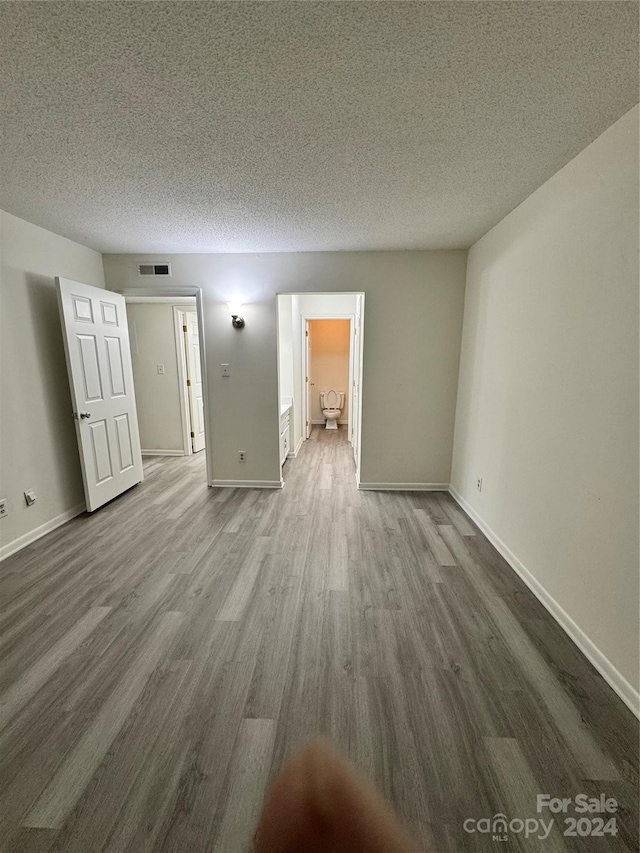 unfurnished room featuring a textured ceiling and hardwood / wood-style flooring