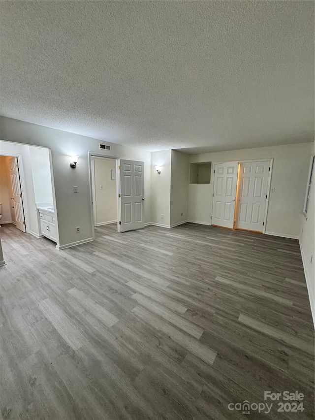 unfurnished living room featuring a textured ceiling and hardwood / wood-style flooring