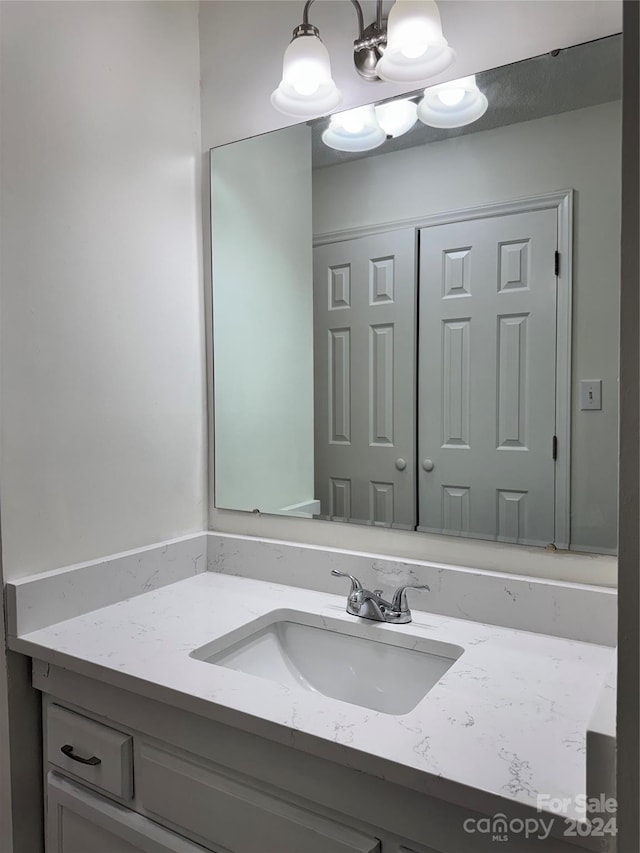 bathroom with vanity and a notable chandelier