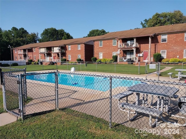 view of swimming pool with a lawn