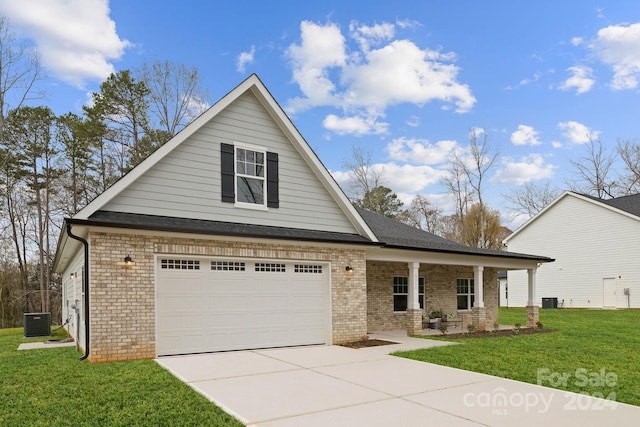 view of front of property with central air condition unit, covered porch, a front yard, and a garage