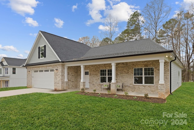 view of front of home with covered porch, a garage, and a front lawn