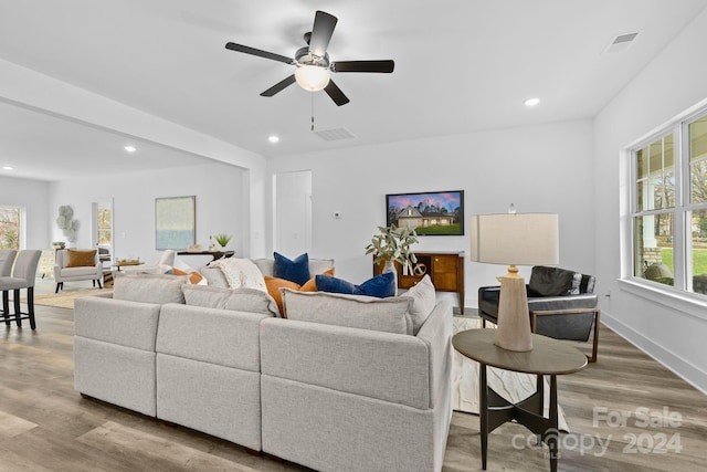 living room featuring ceiling fan and light hardwood / wood-style flooring