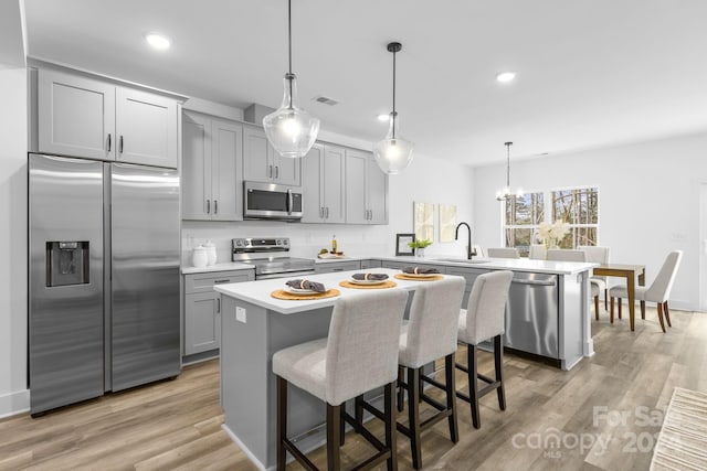 kitchen featuring a breakfast bar area, a center island, light hardwood / wood-style floors, and appliances with stainless steel finishes