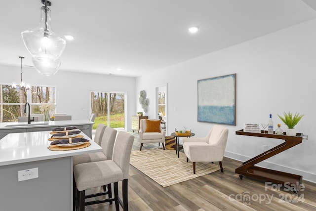 dining space featuring hardwood / wood-style floors, sink, and an inviting chandelier