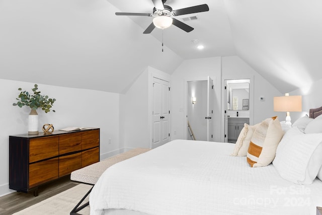 bedroom with ensuite bath, ceiling fan, dark wood-type flooring, and lofted ceiling