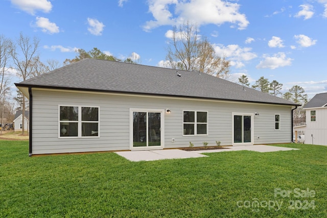 back of house with a yard and a patio