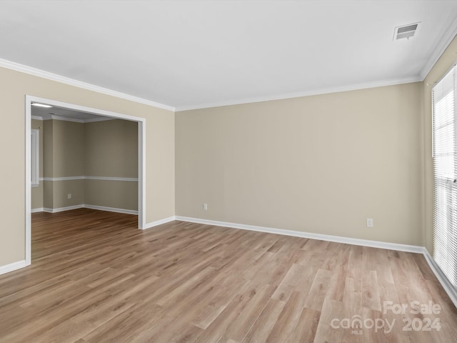 unfurnished room featuring light hardwood / wood-style floors and crown molding