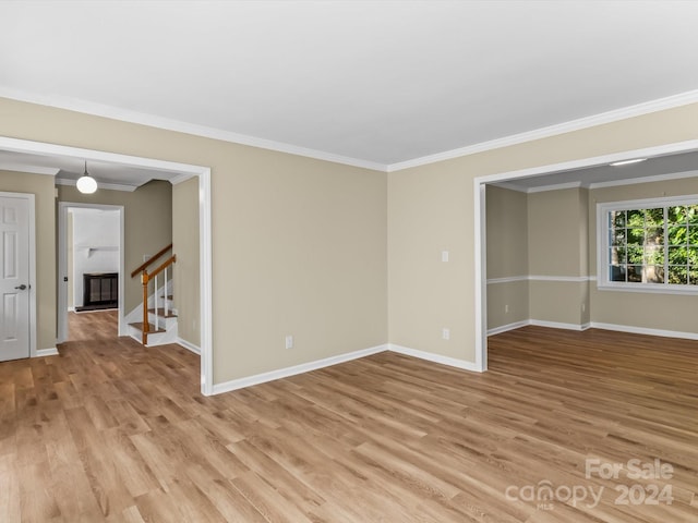 empty room featuring light hardwood / wood-style floors and crown molding