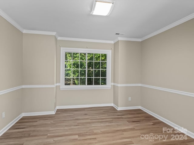 unfurnished room with crown molding and light wood-type flooring