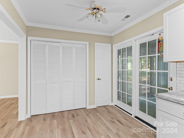 unfurnished bedroom with a closet, ceiling fan, crown molding, and light hardwood / wood-style flooring