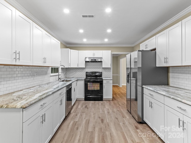 kitchen with light hardwood / wood-style flooring, appliances with stainless steel finishes, sink, and white cabinets