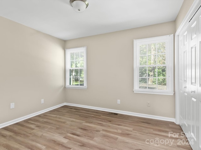 spare room with light hardwood / wood-style floors and a healthy amount of sunlight