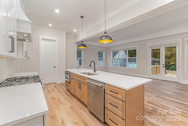 kitchen with pendant lighting, dishwasher, light brown cabinetry, sink, and a center island with sink