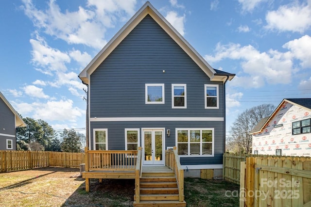 back of house with a wooden deck and french doors