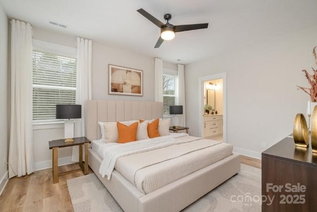 bedroom featuring ceiling fan, ensuite bathroom, and light hardwood / wood-style flooring