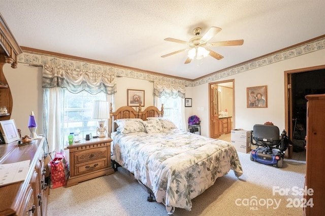 carpeted bedroom featuring a textured ceiling, ensuite bathroom, ornamental molding, and ceiling fan