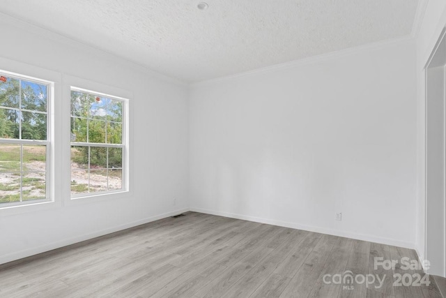 empty room with crown molding, light hardwood / wood-style flooring, and a textured ceiling