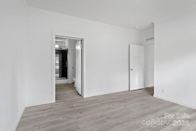 unfurnished room featuring a textured ceiling, light hardwood / wood-style flooring, and ornamental molding