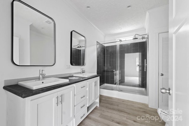 bathroom with hardwood / wood-style floors, walk in shower, toilet, ornamental molding, and vanity