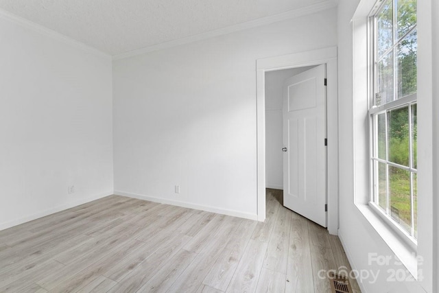 unfurnished room featuring crown molding, a textured ceiling, and light wood-type flooring