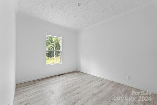 spare room featuring crown molding, a textured ceiling, and light wood-type flooring