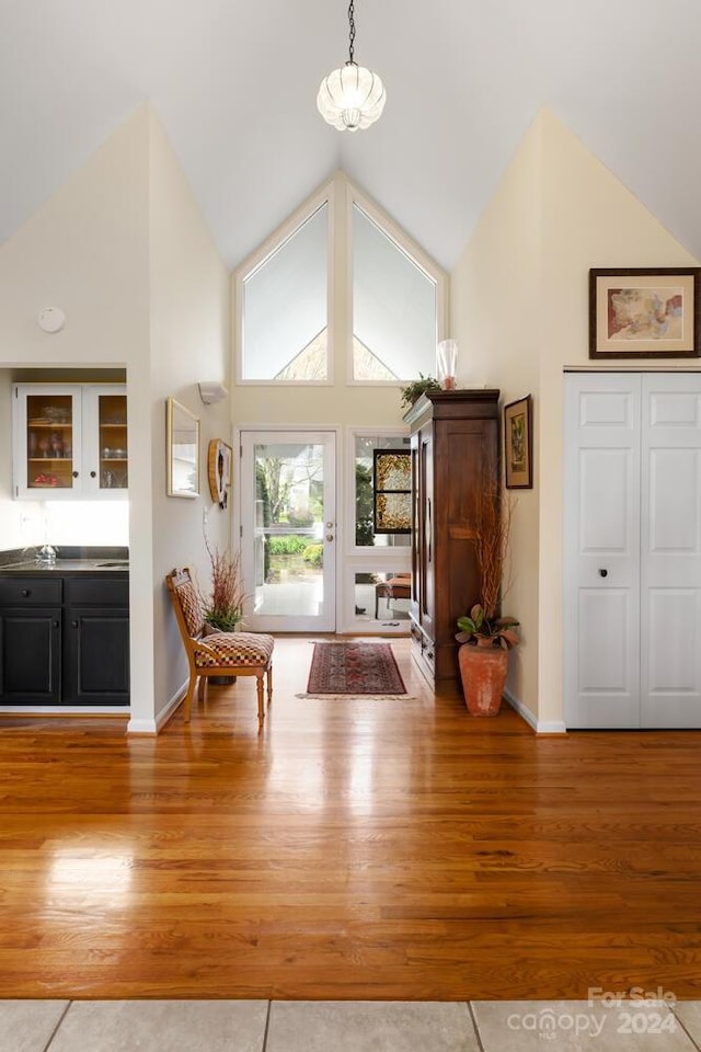 entryway with high vaulted ceiling and hardwood / wood-style flooring