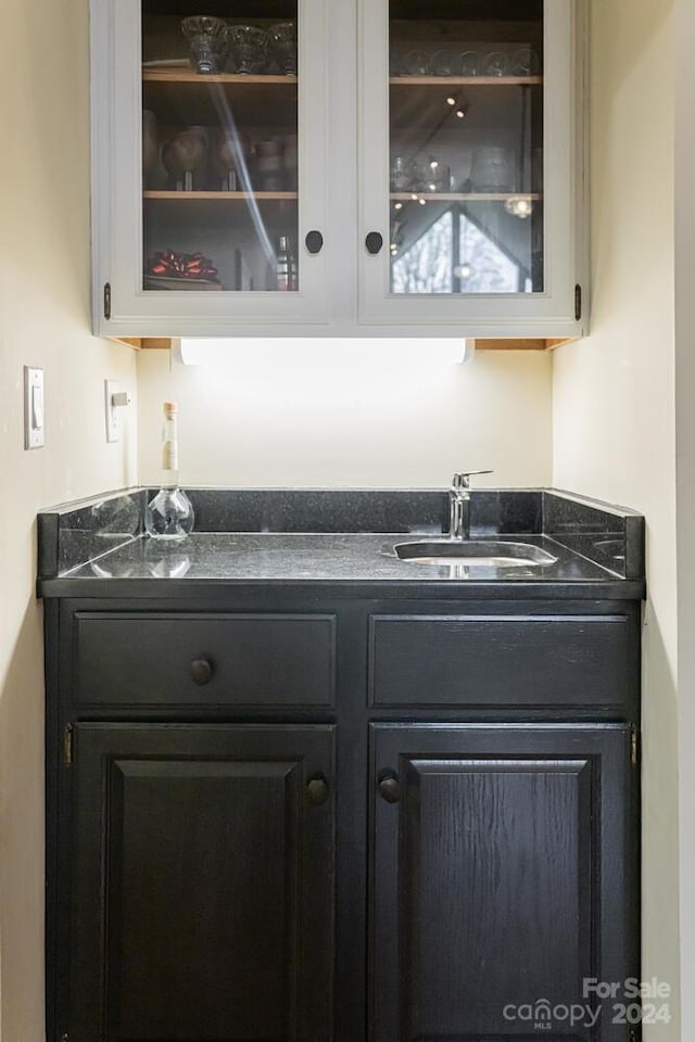 bar featuring white cabinetry and sink