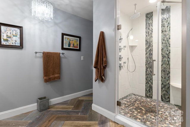 bathroom with parquet flooring, a chandelier, and walk in shower