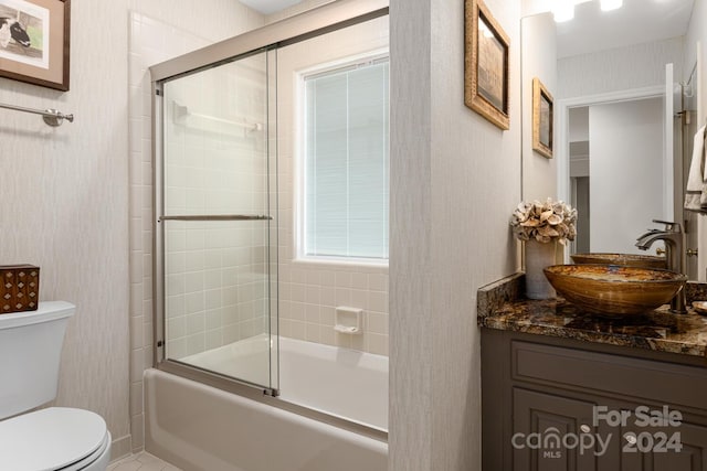 full bathroom with vanity, toilet, and combined bath / shower with glass door