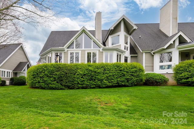 view of front of property featuring central air condition unit and a front lawn